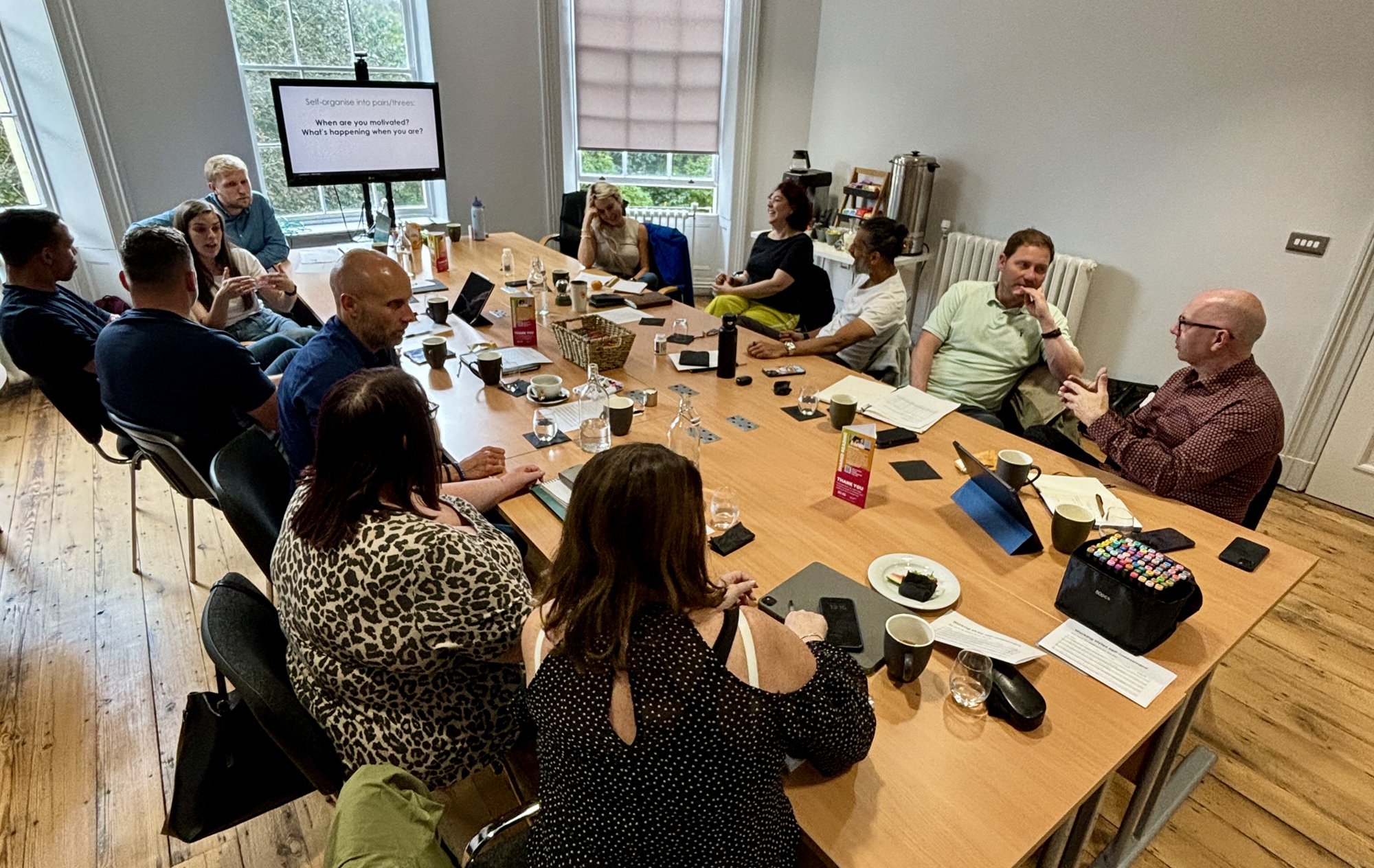 Group reviewing communications artefacts around a table