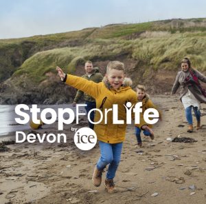 Family Running along a Devon Beach with the Stop For Life Devon logo